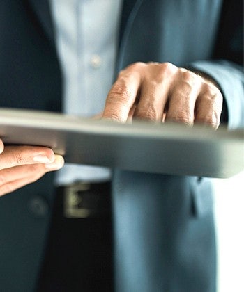 hands typing on a tablet