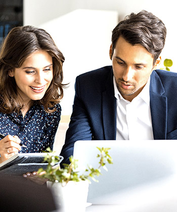 two colleagues looking at a laptop