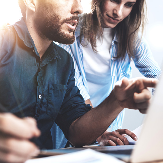 one colleague showing another something on a screen
